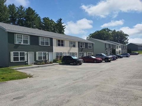 a parking lot in front of a building with cars parked in front