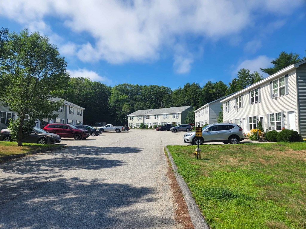 a parking lot filled with cars in front of apartment buildings