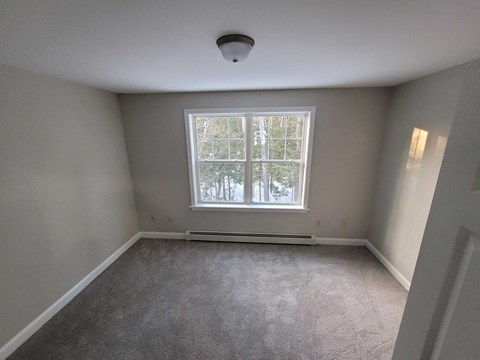 a empty room with a window and carpet