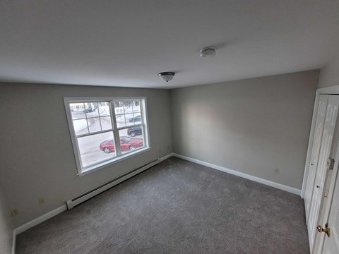 a bedroom with a large window and carpet