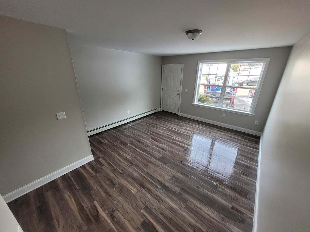 a living room with a hard wood floor and a window