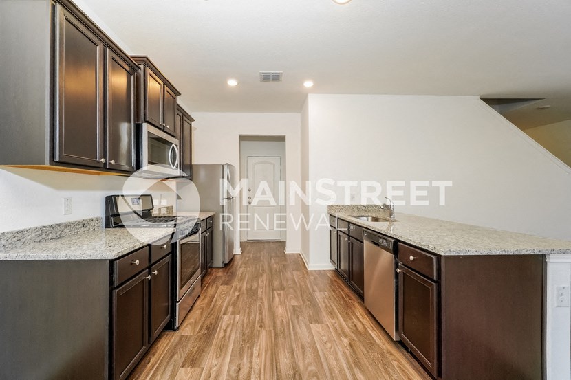 a kitchen with granite countertops and stainless steel appliances