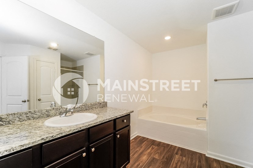 a bathroom with a sink and a bath tub and a mirror