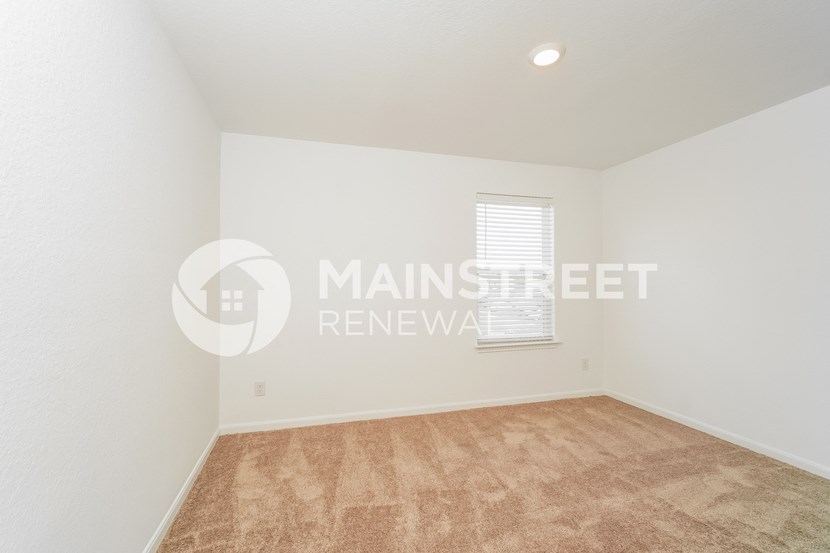 a room with a carpeted floor and a window