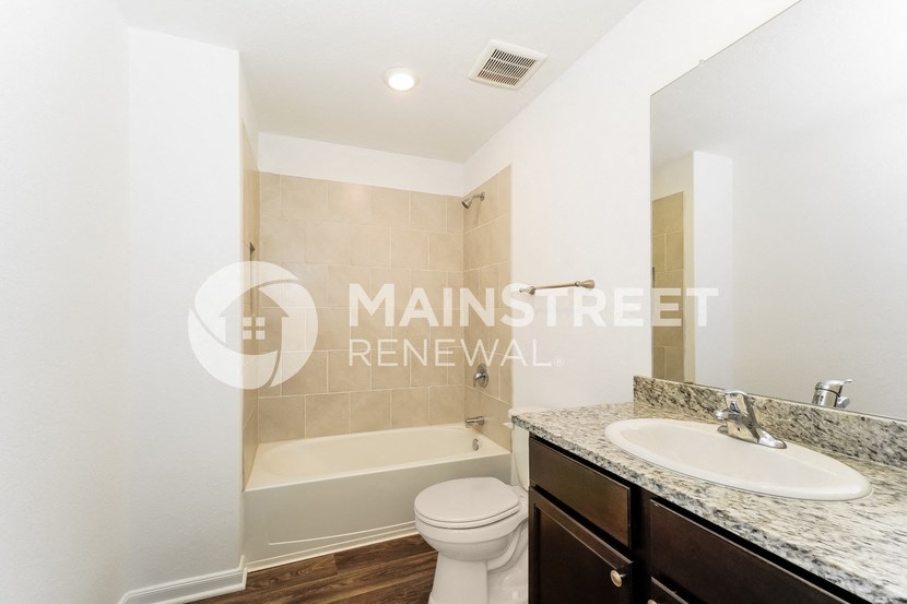 a bathroom with a sink and a toilet and a bath tub