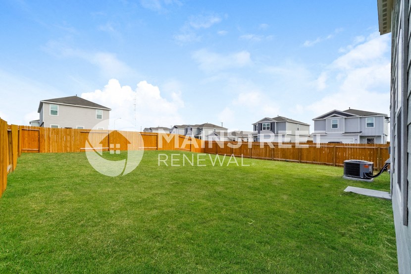 a backyard with a fence and grass
