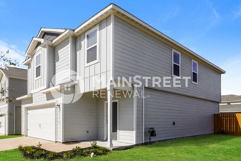 a renovated house with a garage and a lawn