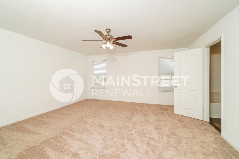 a room with a carpet and a ceiling fan