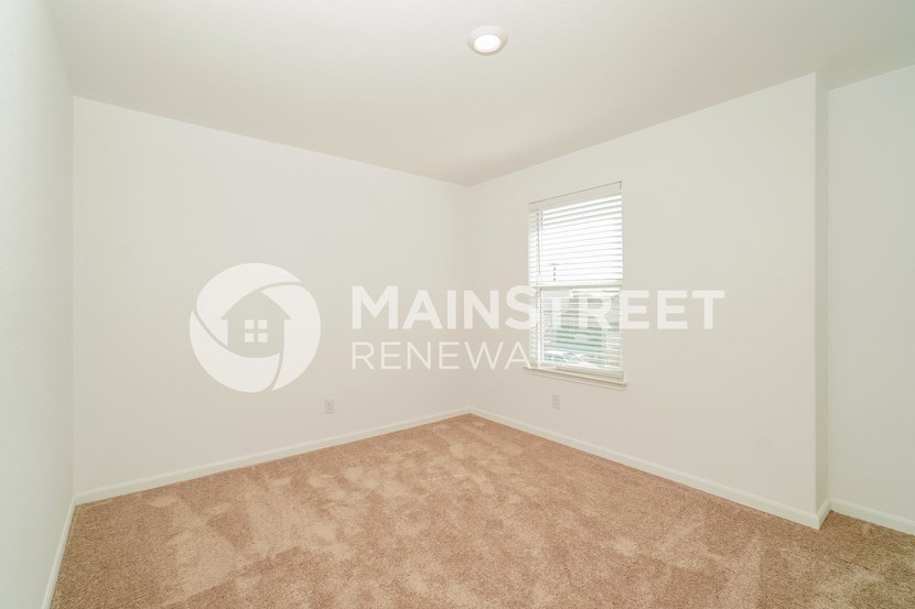 a bedroom with beige carpet and white walls
