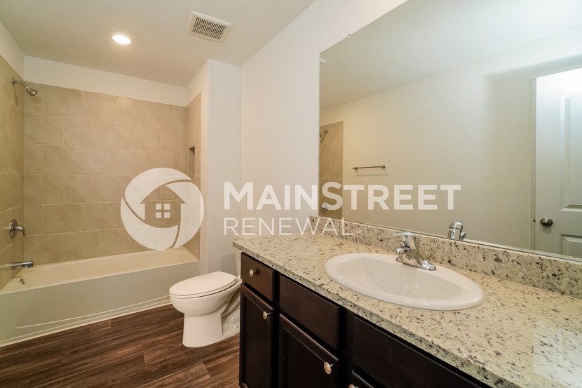 a bathroom with a sink and a toilet and a shower