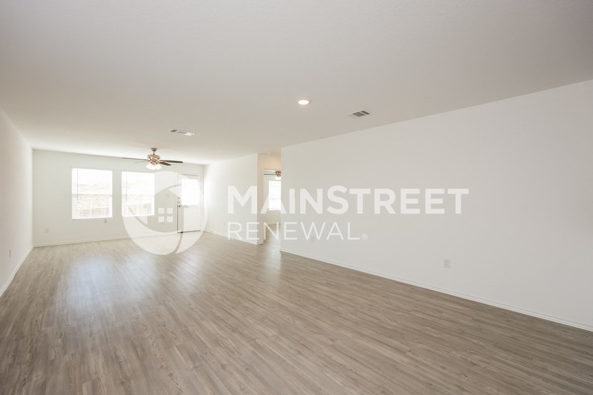 a living room with a hard wood floor and white walls