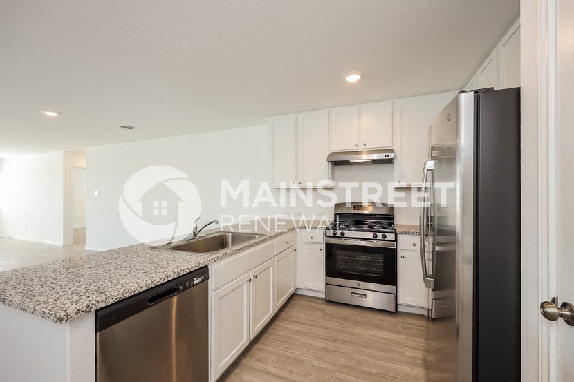 a kitchen with white cabinets and stainless steel appliances