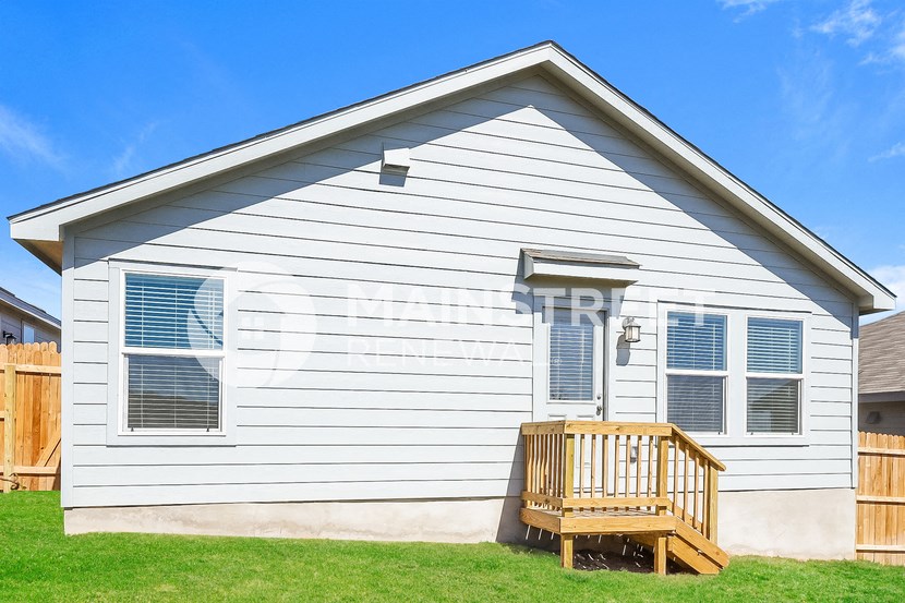 a white house with a deck on the side of it