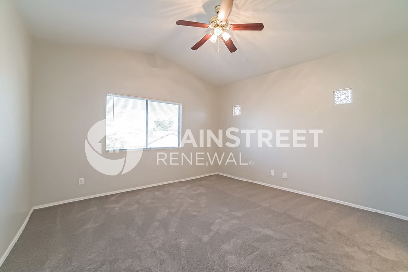 a living room with carpet and a ceiling fan