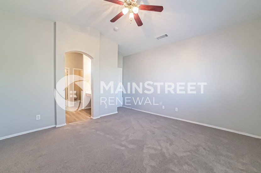 a room with a carpeted floor and a ceiling fan