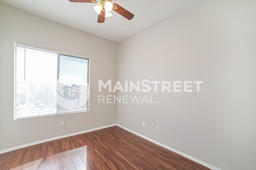 a living room with a ceiling fan and a window