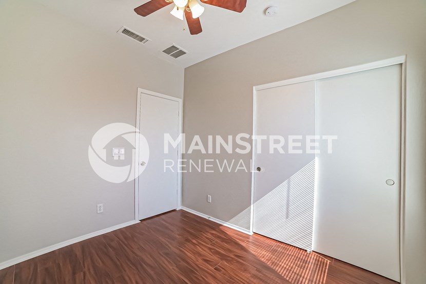 a bedroom with a closet and a door to a hallway