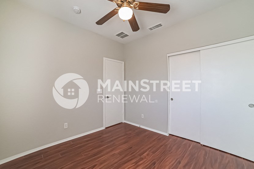 a bedroom with a closet and a ceiling fan