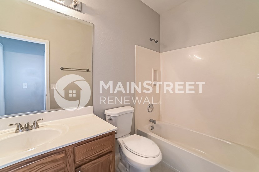 a bathroom with a sink toilet and tub and a mirror