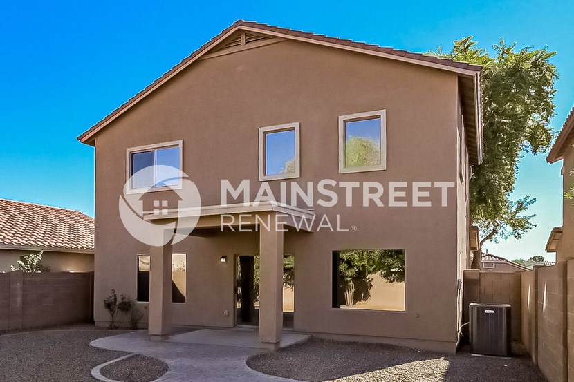 a house with a driveway and a tree in front of it