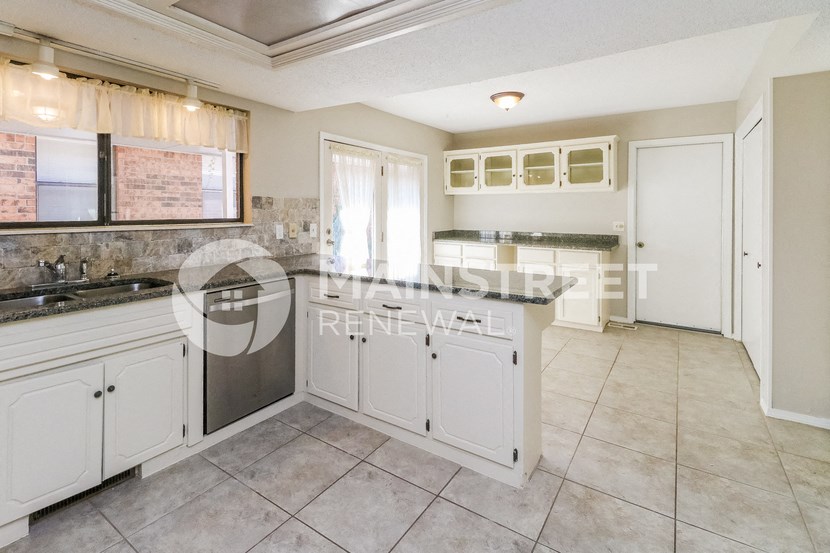 a large kitchen with white cabinets and a counter top