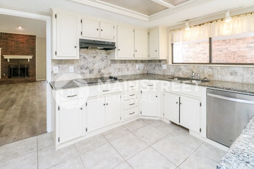 a white kitchen with white cabinets and stainless steel appliances