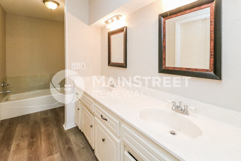 a bathroom with a sink and a mirror and a shower