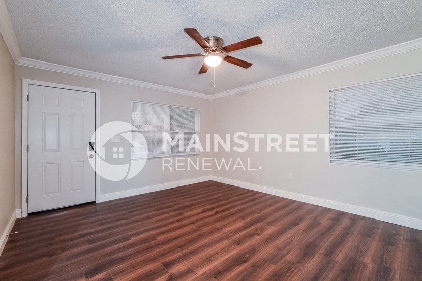 a living room with a wood floor and a ceiling fan