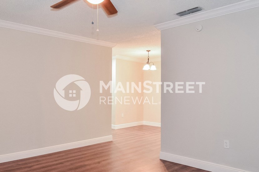 a living room with a wood floor and a ceiling fan