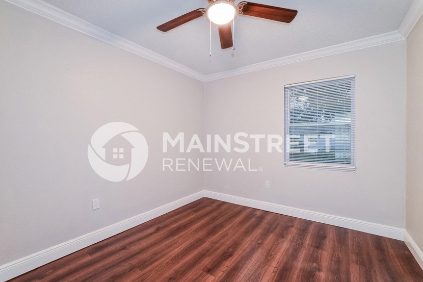 a living room with hardwood floors and a ceiling fan