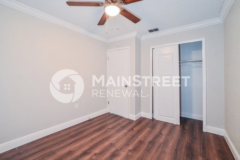 a renovated living room with a ceiling fan and a closet