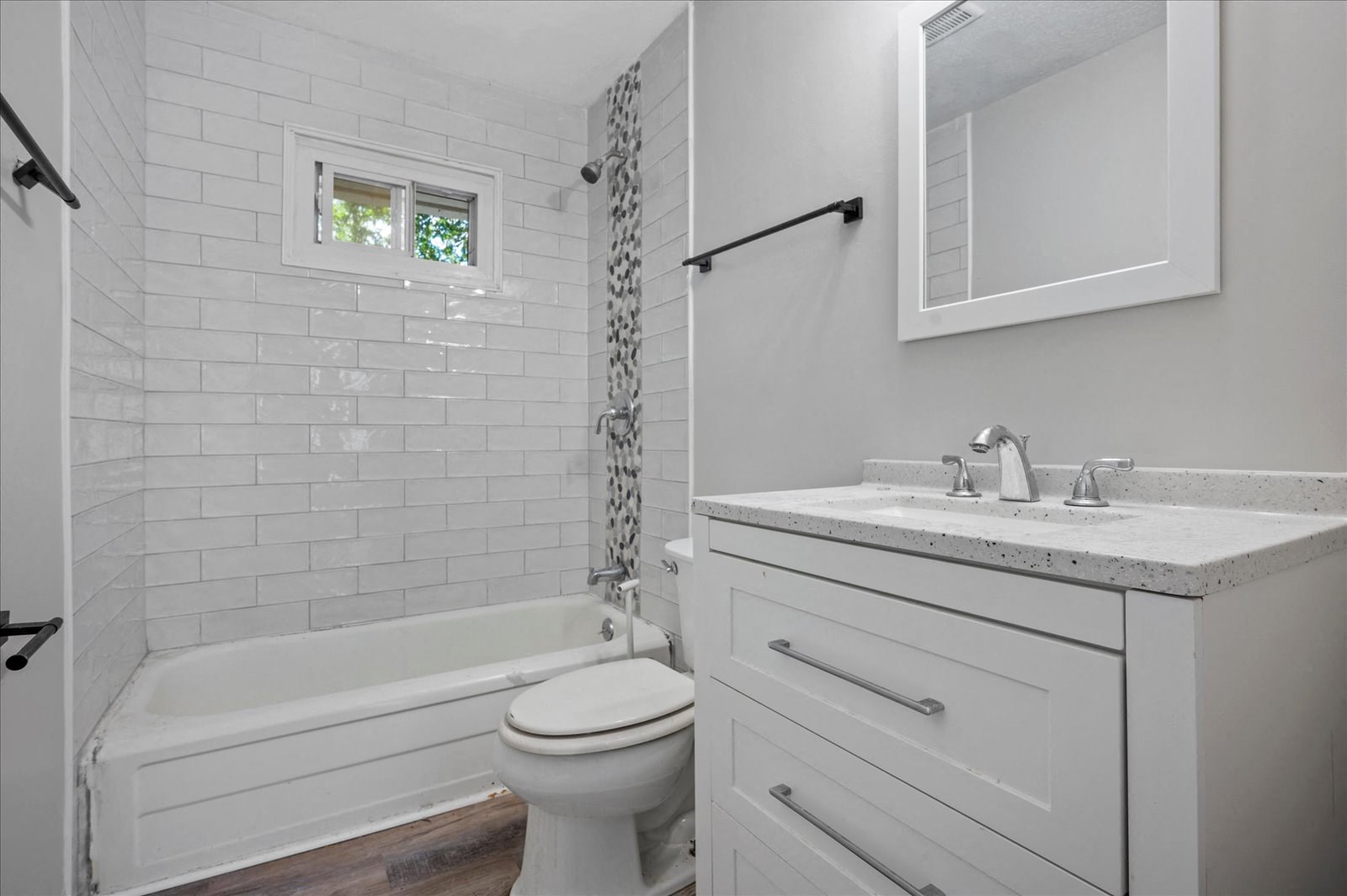 A white bathroom with a toilet, sink, and bathtub.