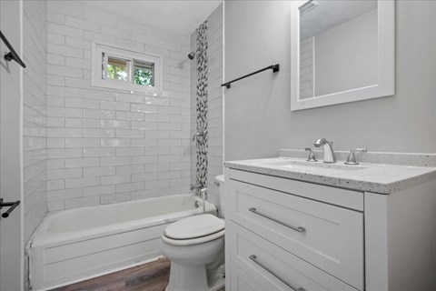 A white bathroom with a toilet, sink, and bathtub.