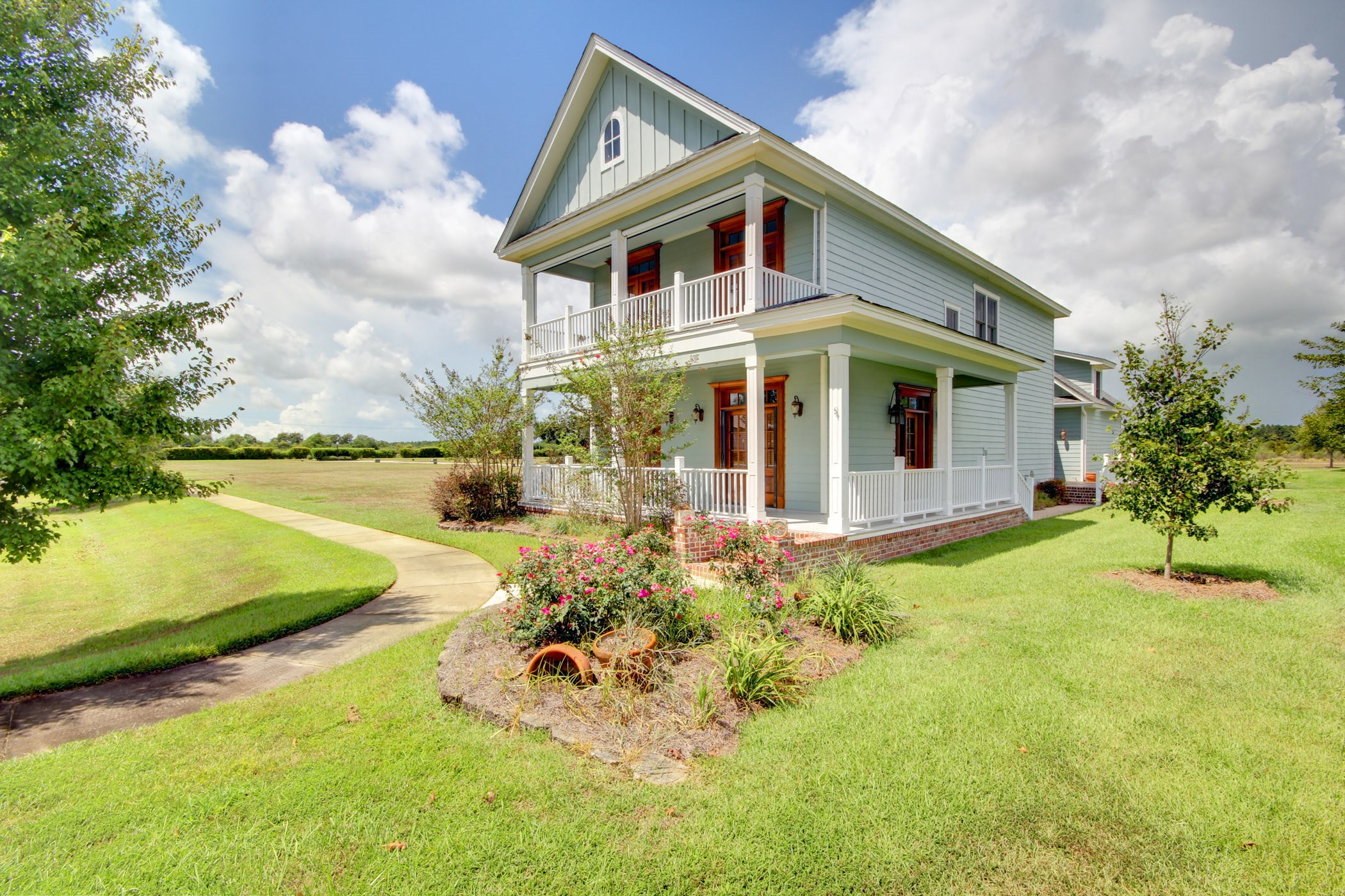 a white house with red shutters and a lawn and a pathway