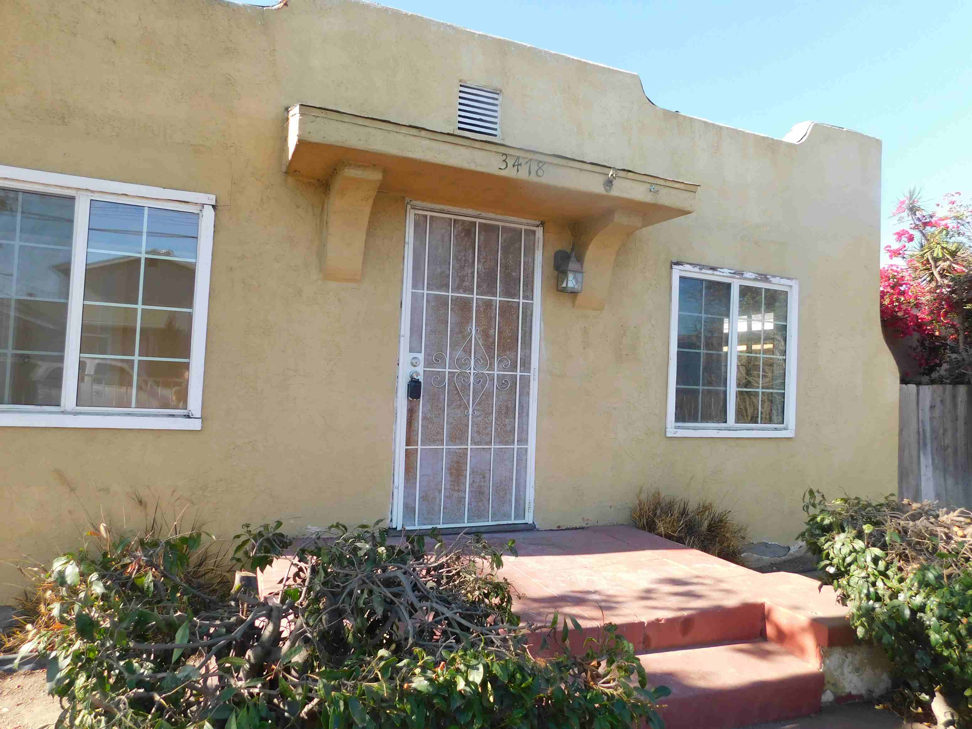 the front of a house with a glass door and a porch
