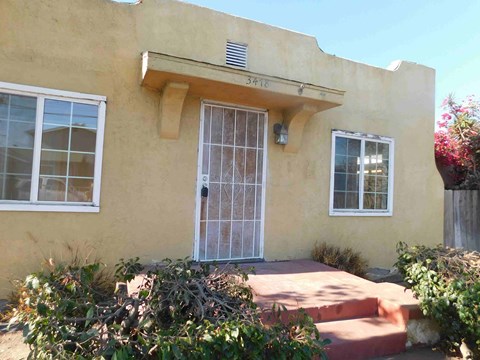 the front of a house with a glass door and a porch