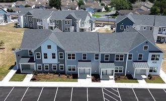 an aerial view of a blue house with a parking lot