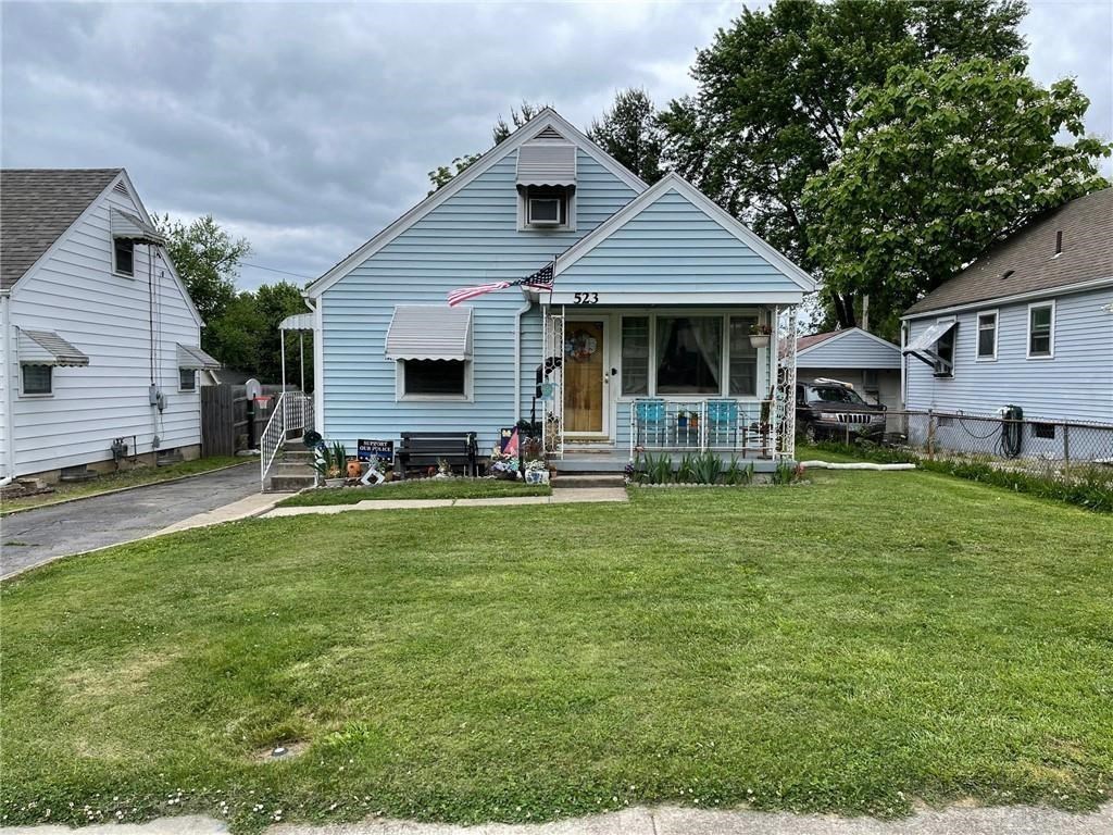 a blue house with a lawn in front of it