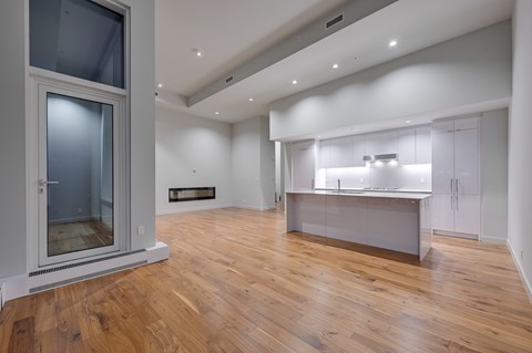 A modern kitchen with wooden floors and white walls.