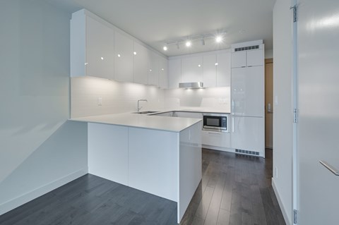 A modern kitchen with white cabinets and a stainless steel oven.