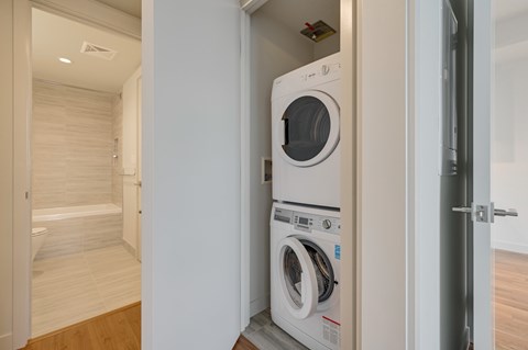 A white washing machine and dryer in a small room.