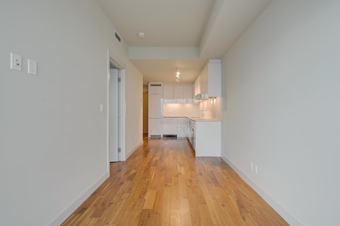 A long hallway with a kitchen at the end.