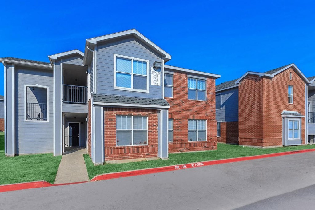 a row of brick and gray apartments on the side of a street