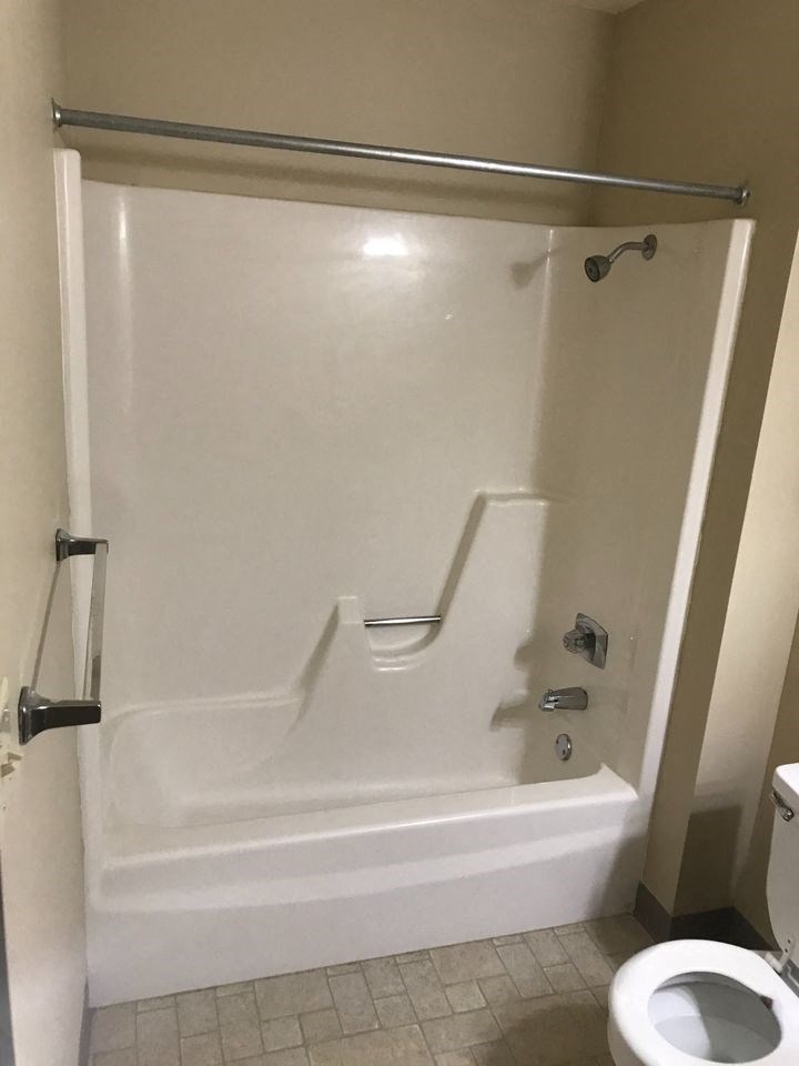 a white bathroom with a shower and a toilet