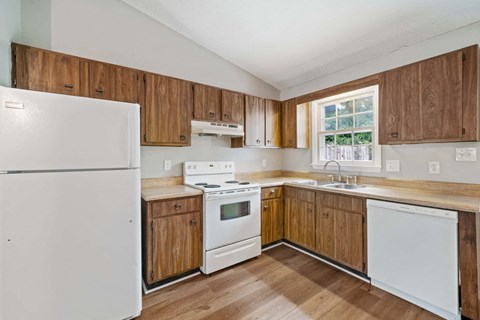 a kitchen with white appliances and wooden cabinets