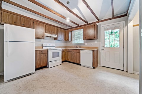 A kitchen with wooden cabinets and a white refrigerator.