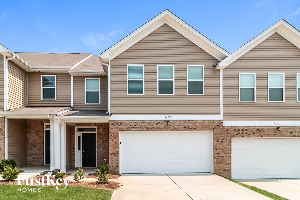 a brown house with two garage doors