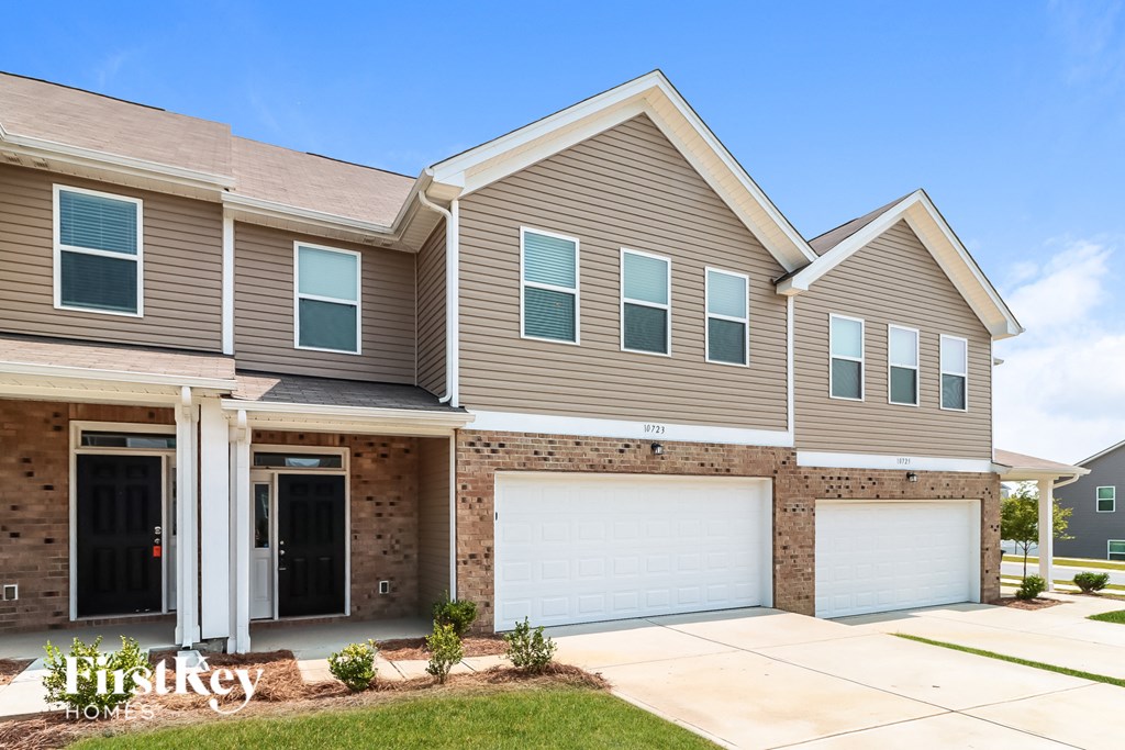a tan and brown house with a garage door