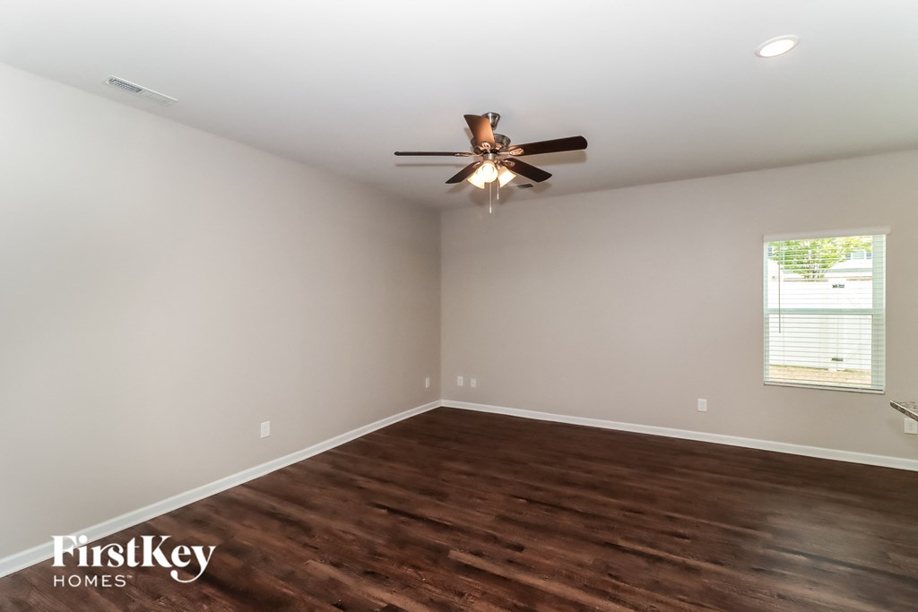 the living room with hardwood flooring and a ceiling fan