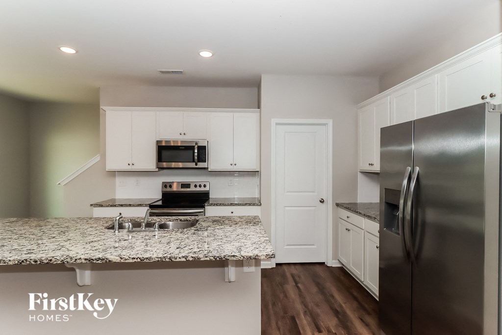 a kitchen with granite countertops and stainless steel appliances